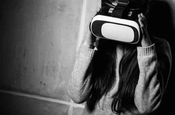Young girl playing mobile game app on virtual reality headset device.Modern VR box for mobile gaming.Portable vr glasses technology for gamers.Augmented reality gadget to play moblie games