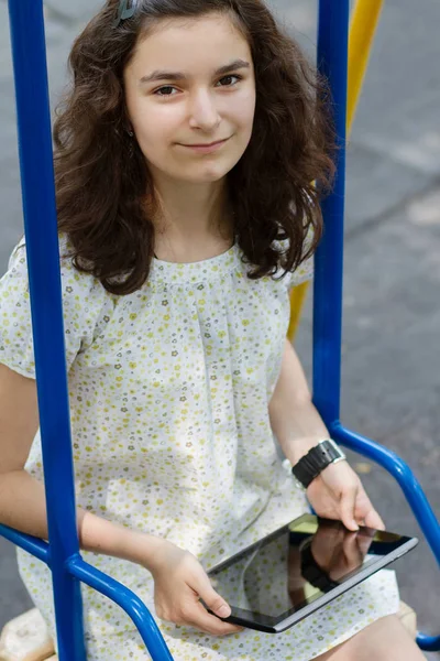 明るい夏ダで公園で彼女はタブレット で遊んでかなり 代の少女 — ストック写真