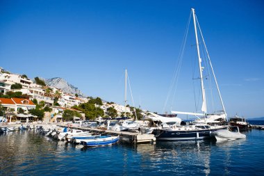 Brela, Hırvatistan-26 Haziran, 2017:Motor tekne ve rıhtımda mavi koyu Adriyatik Sea.Beautiful içinde kiralama yat yaz tatili için hedef seyahat. Egzotik tropik ada için tatil için Kiralık su tekne gezisi