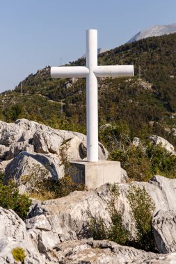 Hırvatistan 'da dağ beyaz Hıristiyan haç heykeli. dini sembolü güneşli yaz gününde tepe vurdu üzerinde yer. Güzel manzara ve iyi hava.