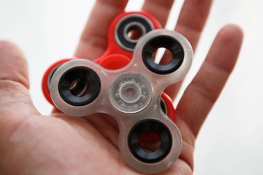 Parmak spinner oyuncak yatakları üzerinde. Süper popüler iplik aygıt. Topluca spinners ile oynarken zevk. Serin plastik Gadget eğlenmek için döner. Adam elinde güzel mekanik karşı oyun