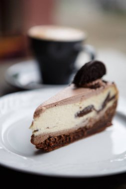 Arka plan üzerine kakao krema ve latte kahve fincan lezzetli çikolatalı kek. Tatlı pasta ürün restoranda beyaz plaka üzerinde dikey bir kadeh. Pasta Cafe menü öğesi