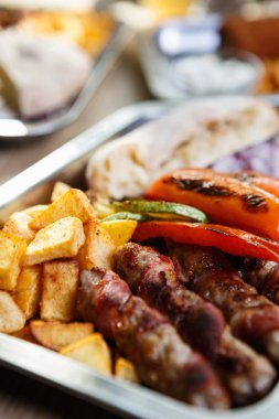 Kafede lezzetli egzotik fastfood menü. Geleneksel Sırp yemek menüsü ile kavrulmuş et, peynir füme ve kızarmış patates. Gıda kompozisyon arka plan. Atış yiyecekleri kapatın