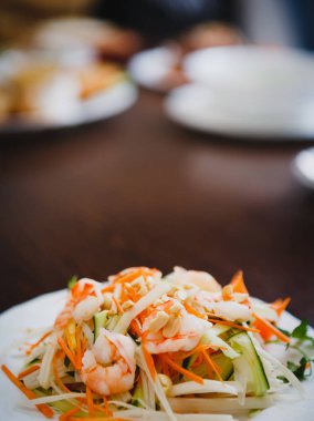 Vietnam restoranı menüde beyaz tabakta lezzetli karides salatası sebze ile servis. Egzotik Asya Cafe gıda. Sağlıklı ve baharatlı yemek. Fıstık ve karides üzerinde odaklanmak