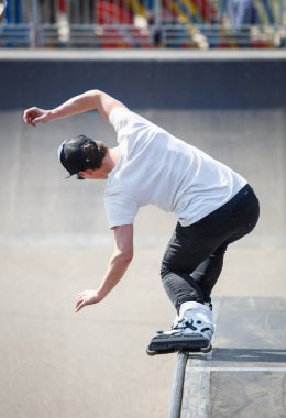 Kiev - 15 Nisan, 2018: agresif satır içi skate Yarışması açık skatepark içinde. Genç kaykaycı çocuk demiryolu üzerinde rulman ağızları ile biler..
