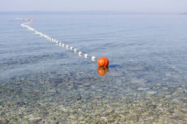 Emanet denizciler ve tehlikeli kayalar uzak yüzücüler suda tutmak için Adriyatik Denizi'nde sürüklenen şamandıralar. Turuncu şamandıra güneş altında açık denizde dalgalar üzerinde yüzen