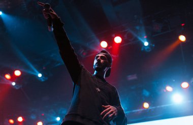 Moskova - 20 Ekim, 2016: Rap şarkıcı şarkı sahne gece kulübü. Hip hop müzik sanatçı şarkı mikrofon sahnede. Rapçi parlak konser aydınlatma.