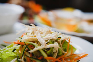 Beyaz haşlanmış tavuk eti, dilimlenmiş taze salatalık ve havuç Asya kafede beyaz tabakta iyi diyet Çin salatası. Egzotik yiyecek Restoran geleneksel Vietnam mutfağında.