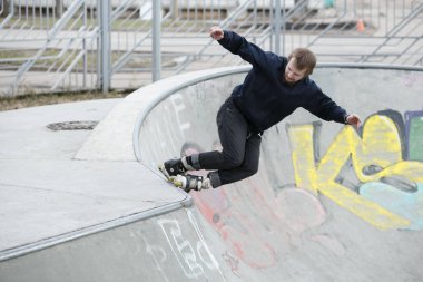 Moskova - 25 Mart, 2017: genç agresif Inline patenci adam eziyet çıkıntının üzerinde aşırı hatlı tekerlekli paten açık skate park sokak skate Yarışması sırasında demiryolu ile