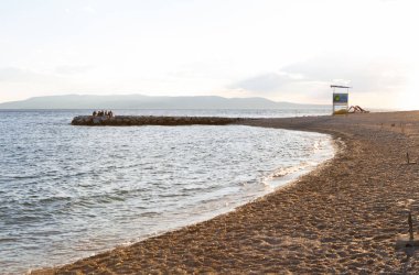 Makarska, Hırvatistan-18 Haziran, 2017: Güzel sahil Adriyatik Denizi Croatia.Tourists keyfini çıkarın deniz yaz tatili iyi güneşli akşamları. Baywatch kule sahilde