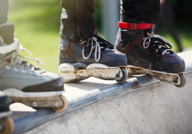 Açık skate Park beton rampa tepesinde duran agresif inline paten giymiş rollerbladers metrelik. Silindir bıçakları için hile ve biler giyen aşırı spor atlet