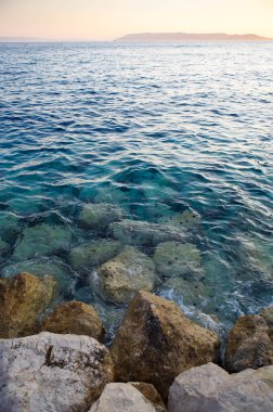 Yaz tatil seyahat için popüler seyahat hedef. Sahilde güzel günbatımı ışık. Kristal berraklığında su kayalık sahil Adriyatik Denizi Croatia.Awesome scape Oda yıkar