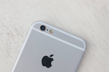 Ahşap yüzey üstünde hareket eden telefon. Modern smartphone modeli, büyük gümüş dava. 