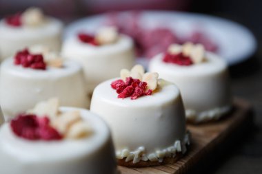 Bu lezzetli küçük kek ahududu ile hizmet Cafe ahşap plaka üzerinde deneyin. Lezzetli İtalyan restoran tatlı gıda menü arka plan