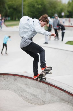 Moskova-15 Mayıs, 2016: yaz Sokak Kaykay Yarışması açık skate park. Aşırı dışında beton skatepark içinde buz pateni. Kaykaycı egzersiz. Aktif dinamik extremal spor. Genç kaykaycı çocuk eziyet eğri çıkıntının üzerinde