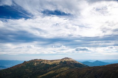 Güney Avrupa'da bulutlu mavi gökyüzü altında güzel dağ manzarası. Kabarık beyaz bulutlar dağ silsilesi içinde Karpatlar üzerinde