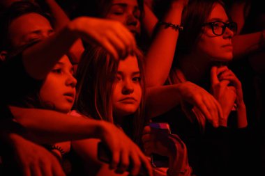 Moskova - 30 Mart, 2017: hip hop konser kameraya bakarak genç sevimli kız. Rap müzik, müzik hayranları ilk satırı göster kırmızı ışıklar. Kalabalıkta bir fotoğraf için poz üzgün küçük kız