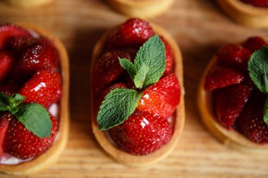 Nane yaprakları ve taze çilek ile deicious çilek cupcakes Tepesi üzerinde bisküvi tabanı üzerinde yemek. Cupcake Cafe tatlıya görüntüsünü kapatın. İtalyan tatlı gıda makro