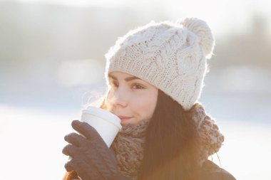 Mutlu kız aromatik kahve içmesine tadını çıkarın. Bir kafeden beyaz net paket servisi olan restoran kağıt bardak. Logonuzu bardakta yerleştirin. Genç ve güzel kadın kış giysileri içinde parlak soğuk gün sıcak olsun 