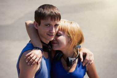 genç bir çift açık havada trendy kablosuz kulaklık poz. iyi çocuklara!