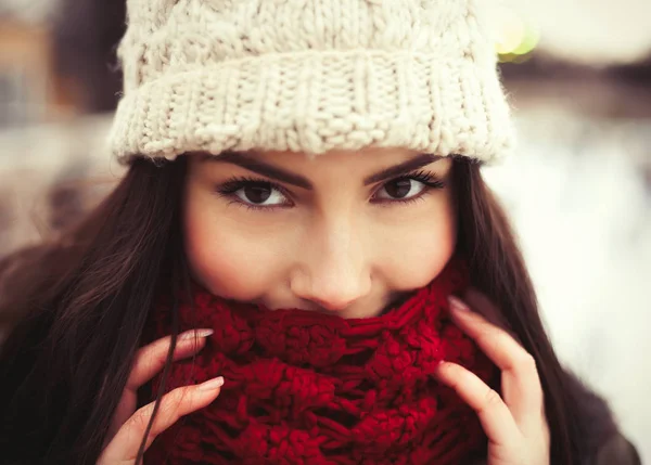 冻的年轻女孩的肖像覆盖着她的嘴唇和脸与温暖的红色围巾 模特微笑着看着镜头 温暖的冬衣在她身上 — 图库照片