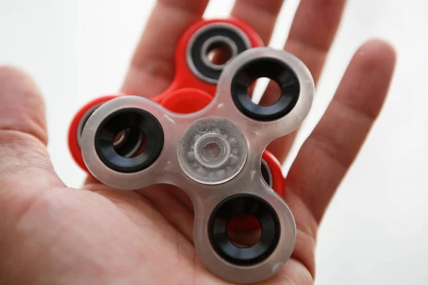 Finger spinner toy on bearings.Super popular spinning device.Enjoy playing with fidget spinners.Cool plastic rotating gadget for fun.Cool mechanical balancing game in man hand