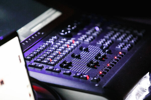 МОСКВА - 30 НОЯБРЯ, 2016: Контроллер освещения концертной сцены. Легкая техническая работа над музыкальным шоу. DMX панель для смешивания огней сцены, сосредоточиться на кнопках ручки и регулятора
