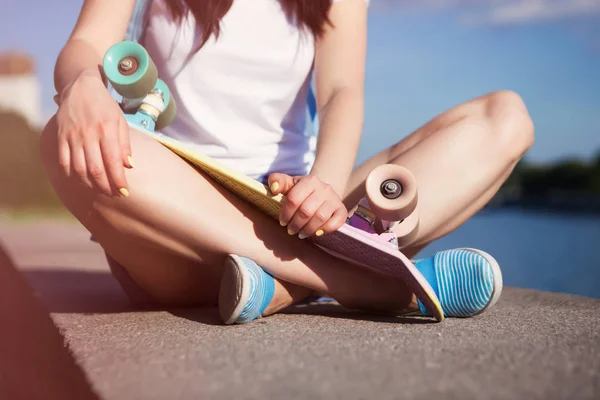 Renkli Kısa Kruvazör Longboard Tutan Bir Kıyıda Oturan Genç Kız — Stok fotoğraf