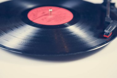 Eski hifi vinil kayıt cihazı. Sehpa, klasik rock müzisyeniyle analog kayıt diski çalar. Klasik ses ekipmanları yakın planda.