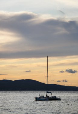 Adriyatik Denizi günbatımında sürüklenen küçük kiralama yat. Gezisi bir motorlu tekne doe yaz tatil kira. Croatia.Dramatic gün batımı aydınlatma arka plan üzerinde doğal güzelliği yakalayın. Gece karanlığında dalış gitmek.