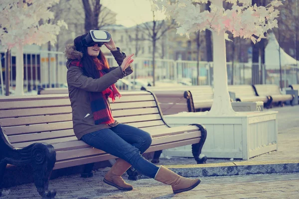 Young girl using  cool new augmented reality glasses for mobile gaming applications.Use mobile games apps with innovative 3d headset. Modern virtual reality gamer gadget.