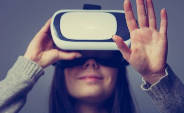 Stüdyo mobil oyun uygulamalar için yeni artırılmış gerçeklik gözlük kullanan genç ve güzel kız portresi. Mobil Oyunlar apps ile yenilikçi 3d vr kulaklık kullanın. Trendy sanal gerçeklik oyun aygıtı kullanımda