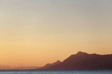 Croatia.Sun'Adriyatik Denizi kıyısında güzel gün batımı dağların üzerinden ufukta aşağı gider. Yaz tatili için egzotik Avrupa resort cruise. Tatil gezi için popüler seyahat hedef