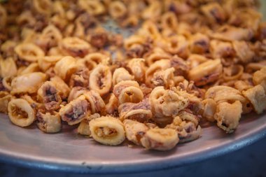 İtalyan deniz ürünleri restoranında metal plaka üzerinde lezzetli kızarmış kalamar. Limon ve baharat ile lezzetli kalamar keyfini çıkarın. İtalya'da geleneksel Akdeniz kafe menüsü