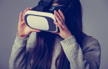 Stüdyo portre genç kızın süper cool sanal gerçeklik gözlük mobil oyun uygulamalar için oynuyor. Mobil apps ile yenilikçi 3d vr kulaklık kullanın. Trendy artar gerçeklik oyun aygıtı kullanımda