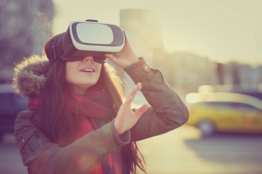 Genç kız mobil oyun uygulamalar için serin yeni sanal gerçeklik gözlük oynamaktan zevk. Mobil apps ile yenilikçi sanal teknolojisini kullanır. Artırılmış gerçeklik oyun Gadget'ı. Kadın oyun vr kulaklığı