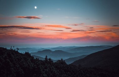 Sonbahar akşam fantastik günbatımı Karpat Dağları'nda. Dağ silueti ve bulutlu gökyüzü moon. Europe.Instagram vintage film filtre aktif Turizm için seyahat hedef