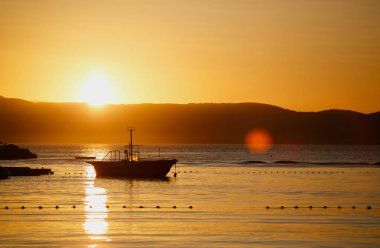 Küçük yat yaz akşamları altın batımında denize sürüklenen. Gece karanlığında Hırvatistan Adriyatik Denizi su üzerinde yüzen küçük motorlu tekne. Güzel seyahat hedef Turizm için. Kiralık Tekne scuba diving için