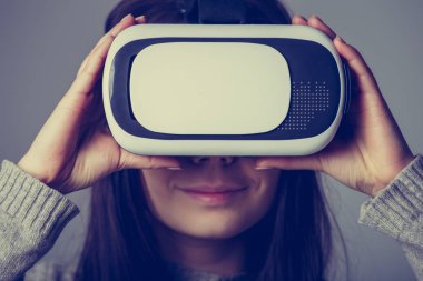 Stüdyo mobil oyunlar apps için yeni sanal gerçeklik gözlükleri tadını Genç beyaz kız portresi. Kız yenilikçi 3d vr mezartaşı ile mobil oyun uygulama kullanın. Trendy augmented gerçeklik gadget oyun