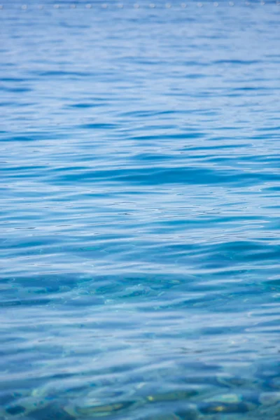 Beautiful vibrant blue sea waves flowing in beach in sunny summer day.Ocean shore with transparent water surface.Go diving and swim in crystal clear Adrtiatic Sea in Croatia.Travel destination