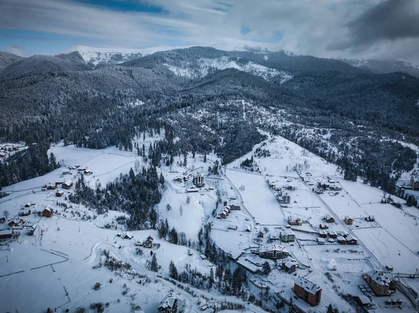 Beautiful aerial drone landscape shot of Carpathian mountains in cold winter day.Forest trees,dramatic sky & snow in Carpahtians.Travel destination for active tourism in Southern Europe