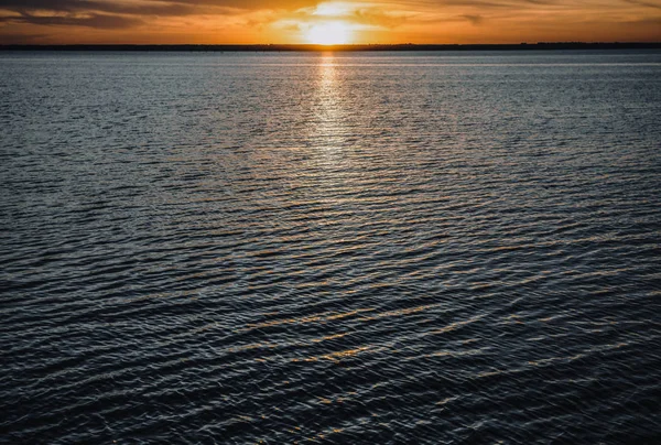 海辺に沈む夕日 夏の夜に水の地平線に夕日が沈みます アクティブな休暇の旅行先 — ストック写真