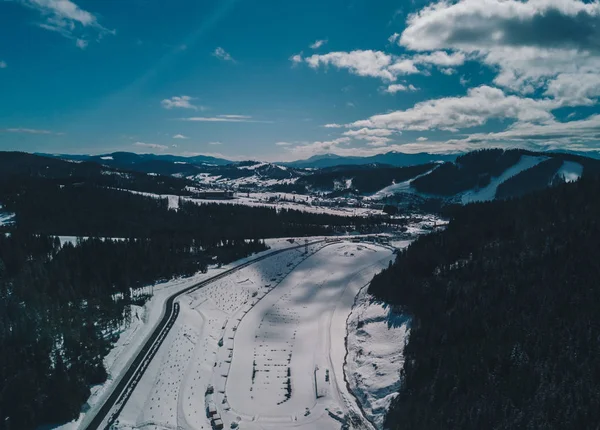 Aerial drone landscape photo of Carpathian mountains in cold winter day.Travel destination for active tourism in Europe.Enjoy beauty of nature in Carpathians.Ski and snow board park from above