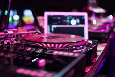 Gece kulübünde sahnede Profesyonel dj tur ntable güverte. Kırmızı ışıklarda sahnede Disk jokey cd çalar cihazı. Modern dijital pikaplar ile kulüp partisinde müzik parçalarını çalın ve remixle 