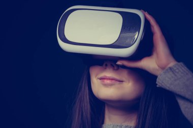 Genç ve güzel kadın için mobil oyun uygulamalar yeni sanal gerçeklik gözlükle stüdyo portre. Kız mobil oyunlar apps ile yenilikçi 3d vr kulaklık kullanın. Trendy artar gerçeklik aygıtı kullanımda
