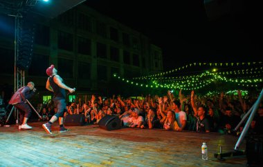 Kiev-11 Ağustos,2018: Rap şarkıcısı Ligalize açık hava gece kulübünde Kurazh yaz müzik festivali sahnede mikrofonda şarkı söylüyor. Dövmeli beyaz rapçi sahnede mikrofonda şarkı lar. Hip hop yıldız performansı 