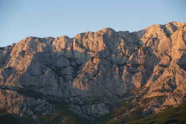 Hırvatistan 'daki Ulusal Park Dağı Biokovo. Yüksek kayalık dağlar akşamları gün batımında parlıyor. Hırvat Riviera' sında yürüyüşe çıkın.