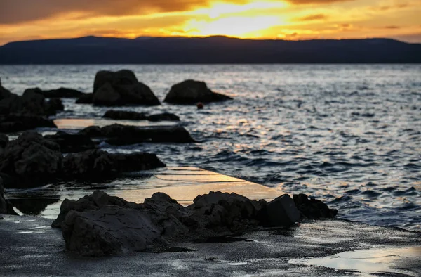 夕方には劇的な日没の光 アドリア海の海岸の Croatia Beautiful の日没の風景に水の地平線に夕日が沈みます ゴールドの黄昏照明で輝いています 海岸に転がっている水波 — ストック写真