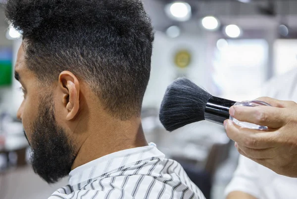 Barber uses shaving brush on clients neck to spread talcum powder for shaving neck with razor in barbershop .Male beauty treatment concept