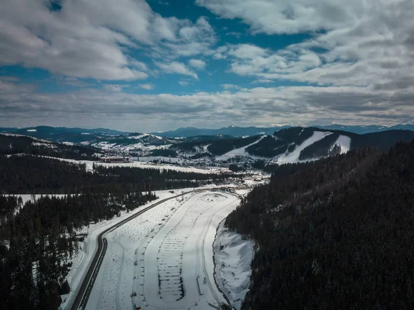 Beautiful aerial drone landscape photo of mountains in cold snowy day. Travel destination for active tourism in winter. Beauty of nature in Carpathian mountain park.
